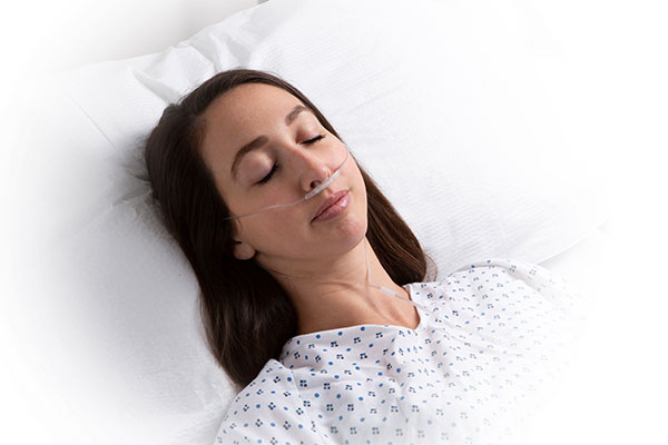 Masimo - Erwachsene Frau in Krankenhausbett mit NomoLine Kapnographie RRc-Produkt